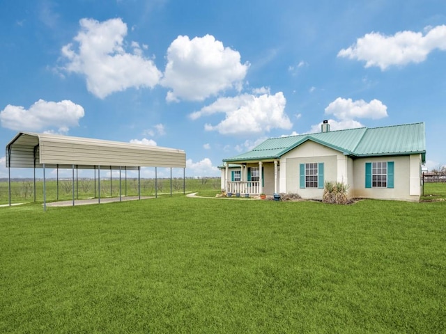 view of front of house with metal roof, a carport, a front lawn, and fence