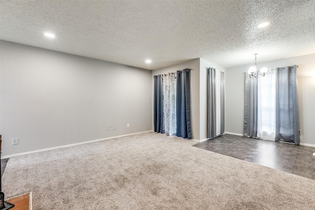 spare room with recessed lighting, carpet flooring, a textured ceiling, a chandelier, and baseboards