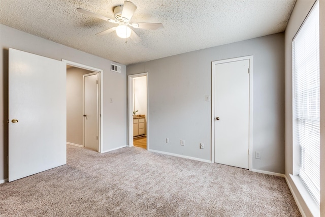 12480 Abrams Rd Unit 321, Dallas, TX 75243 - unfurnished bedroom featuring light colored carpet, a textured ceiling, ensuite bath, and a ceiling fan
