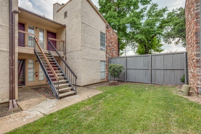 view of yard featuring stairway and fence