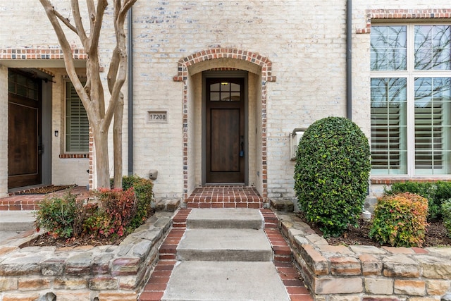 doorway to property with brick siding