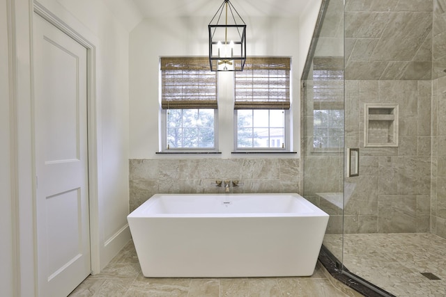 bathroom featuring a chandelier, a stall shower, and a freestanding tub