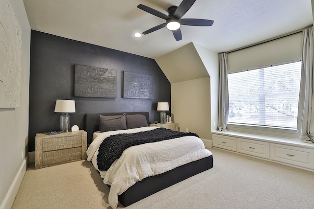 bedroom with ceiling fan, lofted ceiling, a textured wall, light carpet, and baseboards