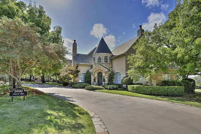 6600 Sahalee Dr, Fort Worth, TX 76132 - view of front of house with stone siding, a chimney, stucco siding, and a front lawn