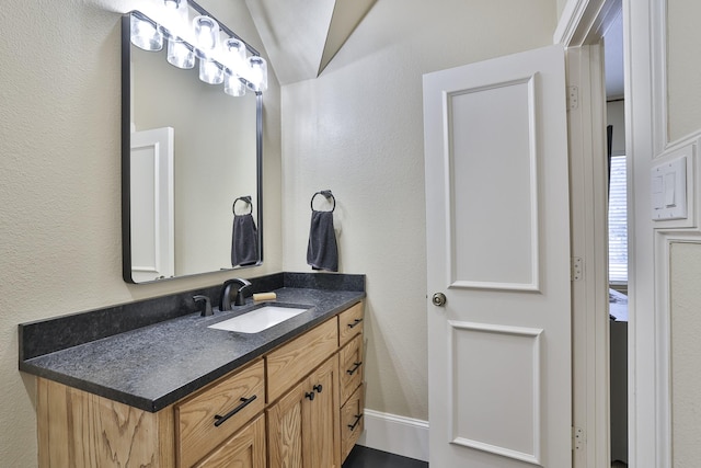 bathroom featuring a textured wall and vanity