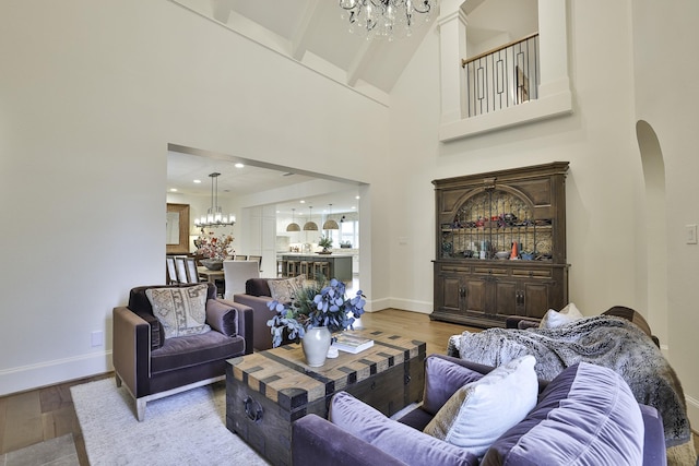 6600 Sahalee Dr, Fort Worth, TX 76132 - living area with a chandelier, wood finished floors, arched walkways, and a towering ceiling