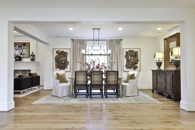 6600 Sahalee Dr, Fort Worth, TX 76132 - dining area with light wood-style floors, a chandelier, recessed lighting, and a tiled fireplace