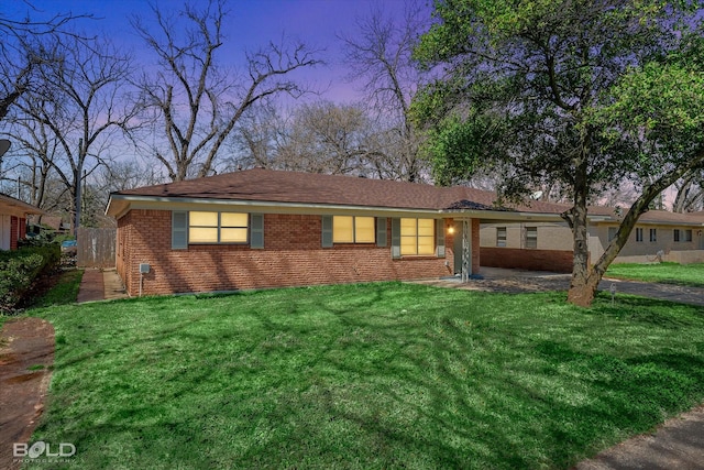 ranch-style home with brick siding and a front lawn