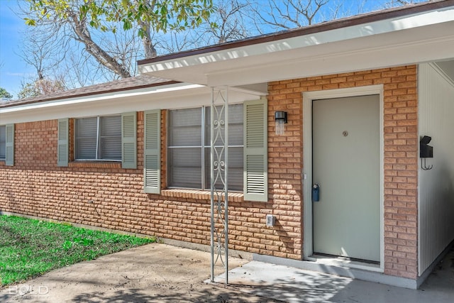 view of exterior entry with brick siding