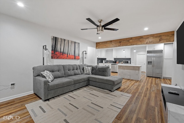 living room with recessed lighting, ceiling fan, light wood-style flooring, and baseboards