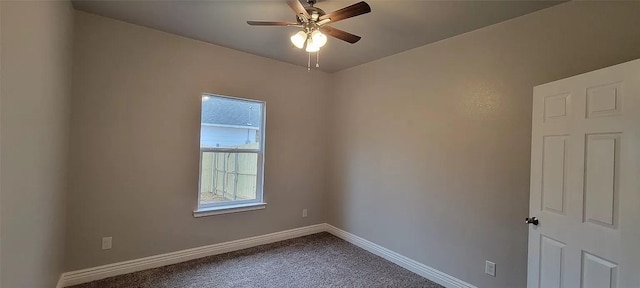 empty room featuring dark carpet, baseboards, and ceiling fan