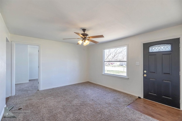 foyer with carpet, a ceiling fan, and baseboards