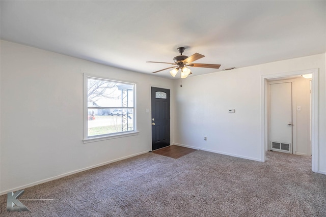 unfurnished room featuring baseboards, visible vents, ceiling fan, and carpet flooring