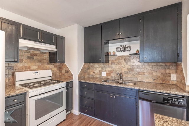 kitchen with under cabinet range hood, a sink, dishwasher, light wood finished floors, and gas range gas stove