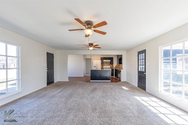 unfurnished living room with a ceiling fan and carpet flooring