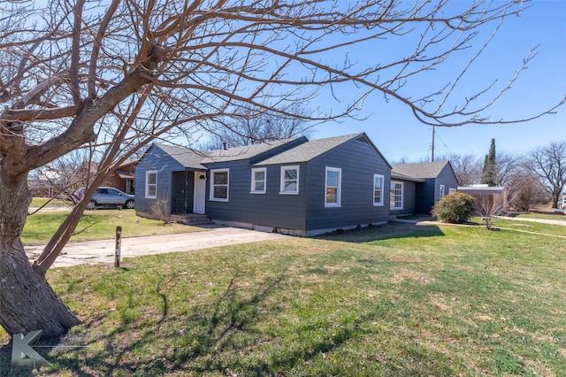 ranch-style home featuring driveway, a front lawn, and a shingled roof