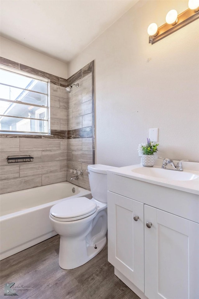 bathroom featuring vanity, bathtub / shower combination, wood finished floors, and toilet