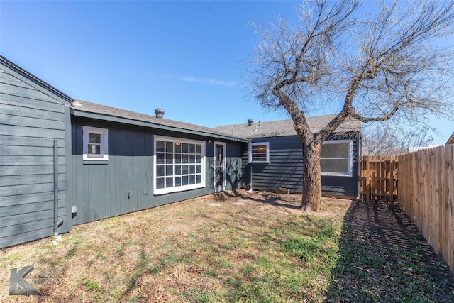 back of house with a yard and fence