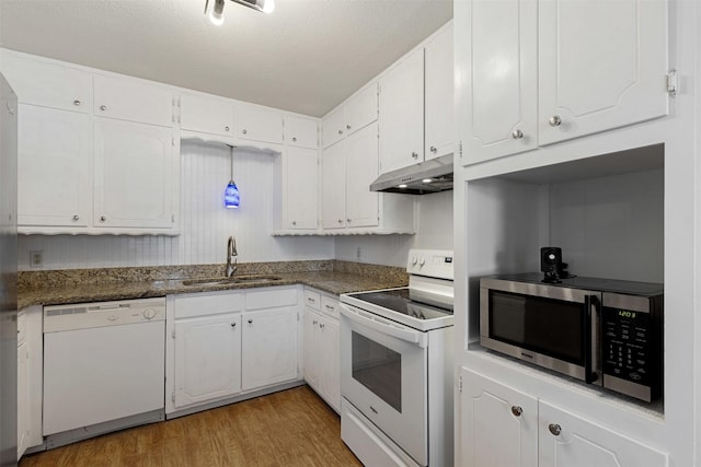 kitchen with under cabinet range hood, white appliances, a sink, white cabinets, and light wood finished floors