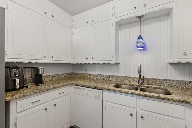 kitchen with stone counters, white cabinets, white dishwasher, and a sink