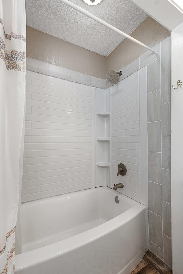 bathroom with shower / tub combo, a textured ceiling, and wood finished floors