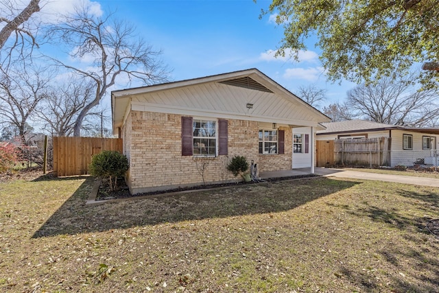 view of front of property featuring brick siding, a front yard, and fence