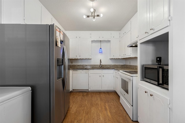 kitchen featuring under cabinet range hood, stainless steel appliances, wood finished floors, a sink, and white cabinets