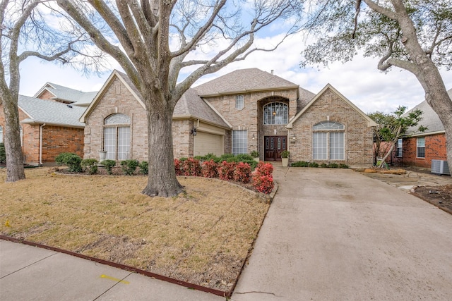 french country home with brick siding, an attached garage, and a shingled roof