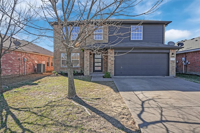 traditional home featuring concrete driveway, an attached garage, central air condition unit, a front lawn, and brick siding