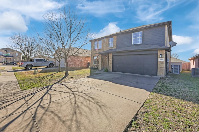 traditional home with driveway, an attached garage, and a front yard