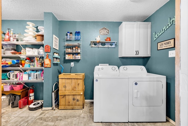 laundry area featuring baseboards, cabinet space, a textured ceiling, and washing machine and clothes dryer