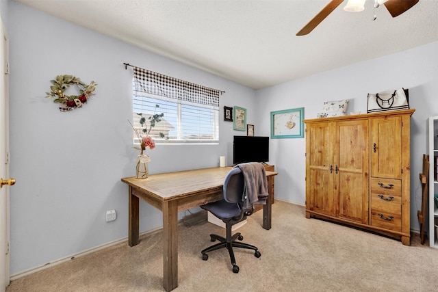 office space featuring light carpet, ceiling fan, and baseboards