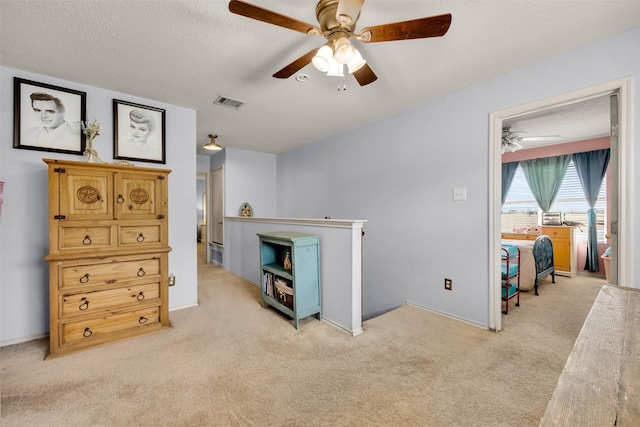 interior space with light carpet, ceiling fan, visible vents, and a textured ceiling