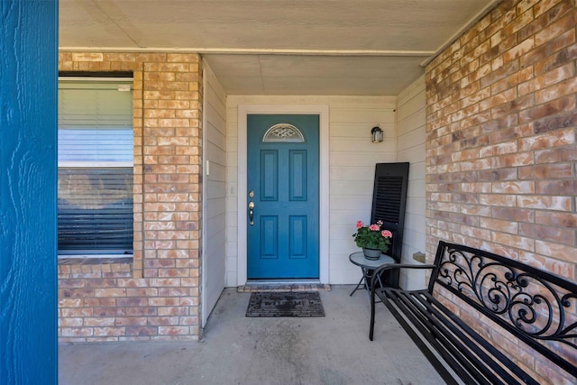 property entrance featuring brick siding