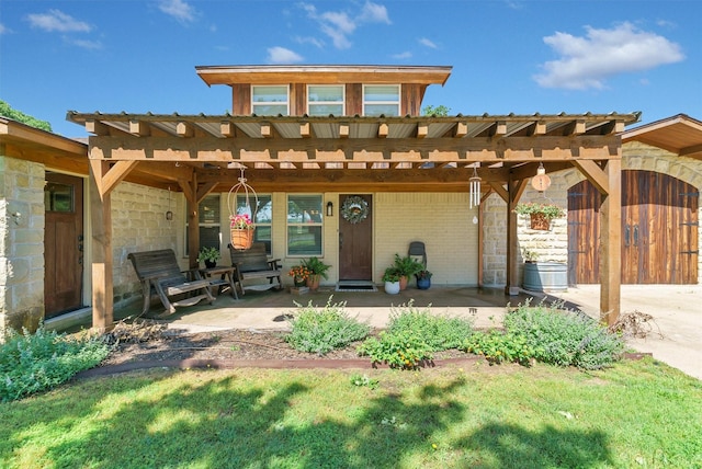 rear view of property with covered porch, brick siding, and a pergola