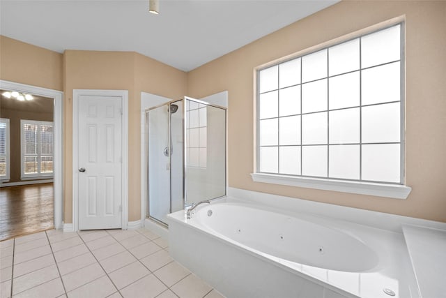 bathroom with a whirlpool tub, baseboards, a shower stall, and tile patterned floors