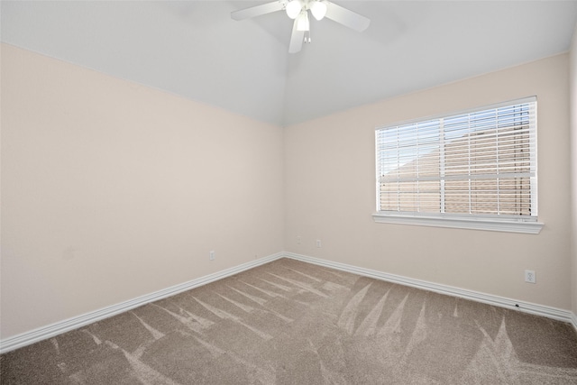 carpeted spare room with lofted ceiling, a ceiling fan, and baseboards