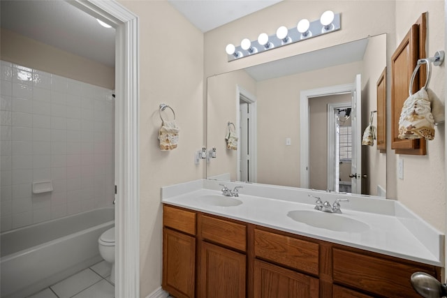 bathroom featuring toilet, double vanity, a sink, and tile patterned floors