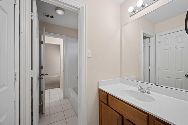 bathroom featuring a bathtub, vanity, visible vents, and tile patterned floors