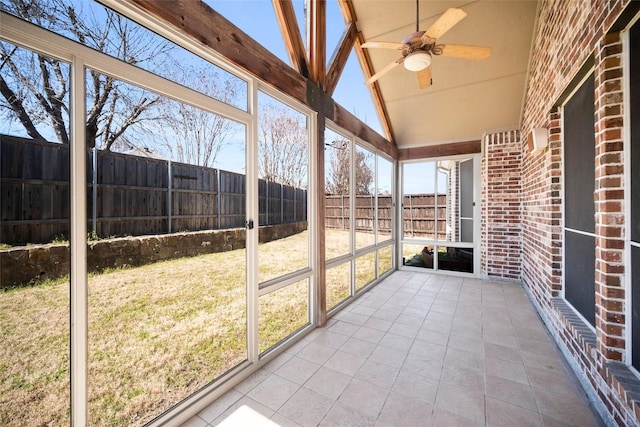 unfurnished sunroom with a ceiling fan and lofted ceiling