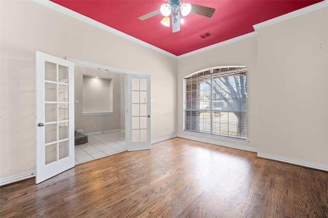 unfurnished room featuring wood finished floors, visible vents, baseboards, french doors, and crown molding