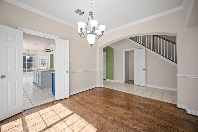 unfurnished room with visible vents, a notable chandelier, a sink, and light tile patterned floors