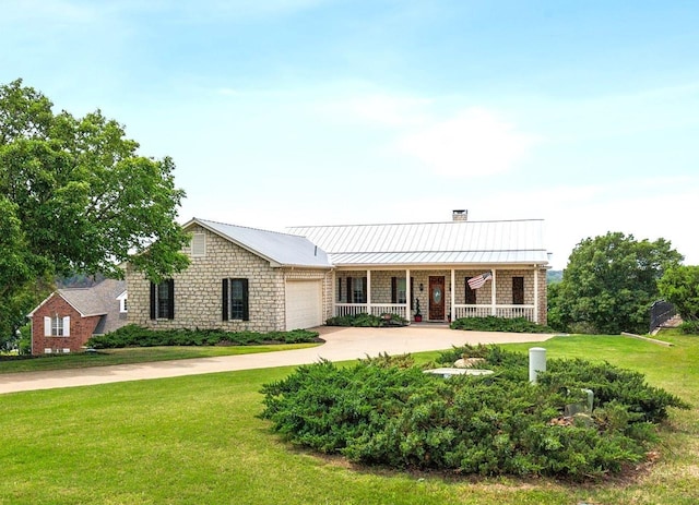 view of front of property with a front yard, covered porch, driveway, and metal roof