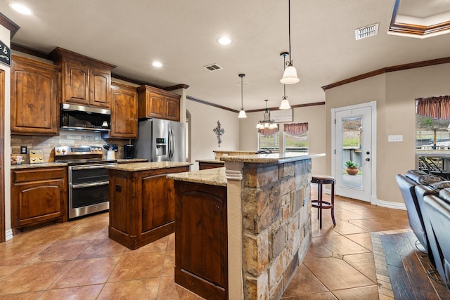 kitchen featuring light tile patterned floors, stainless steel appliances, tasteful backsplash, visible vents, and a kitchen island with sink