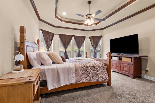 carpeted bedroom featuring a ceiling fan, a tray ceiling, crown molding, and baseboards