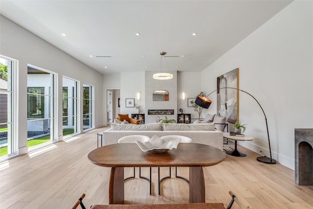 living area with light wood-type flooring, a fireplace, baseboards, and recessed lighting