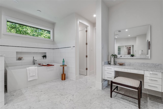 full bathroom featuring recessed lighting, a soaking tub, vanity, and marble finish floor