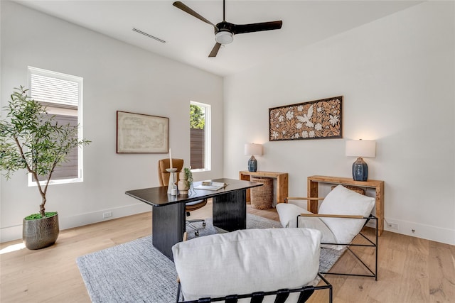 office area featuring ceiling fan, light wood-type flooring, visible vents, and baseboards