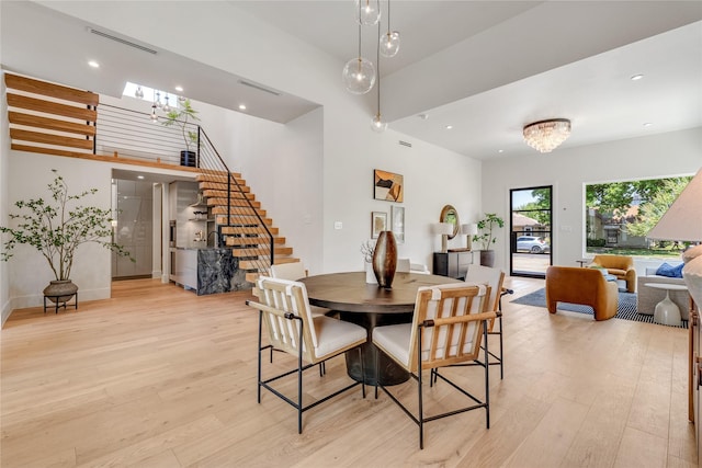 dining room featuring light wood-style flooring, recessed lighting, visible vents, stairs, and an inviting chandelier