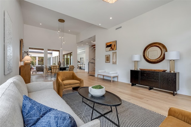 living area featuring light wood-style floors, recessed lighting, baseboards, and stairs